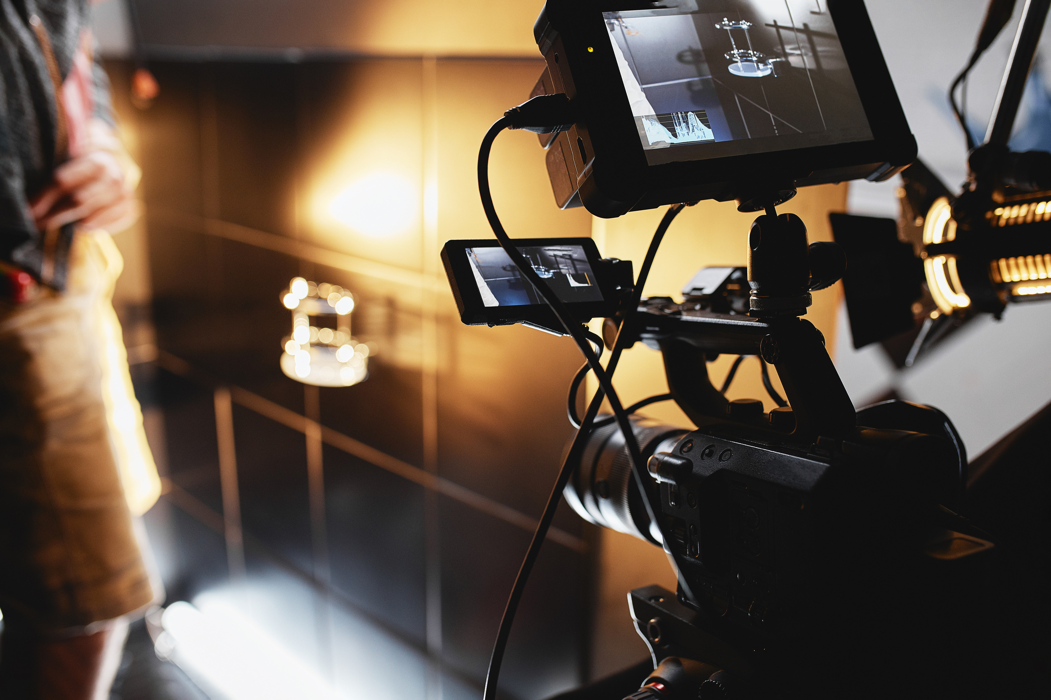 Video production backstage. Behind the scenes of creating video content, a professional team of cameramen with a director filming commercial ads. Video content creation, video creation industry. Low key, selective focus, film graine